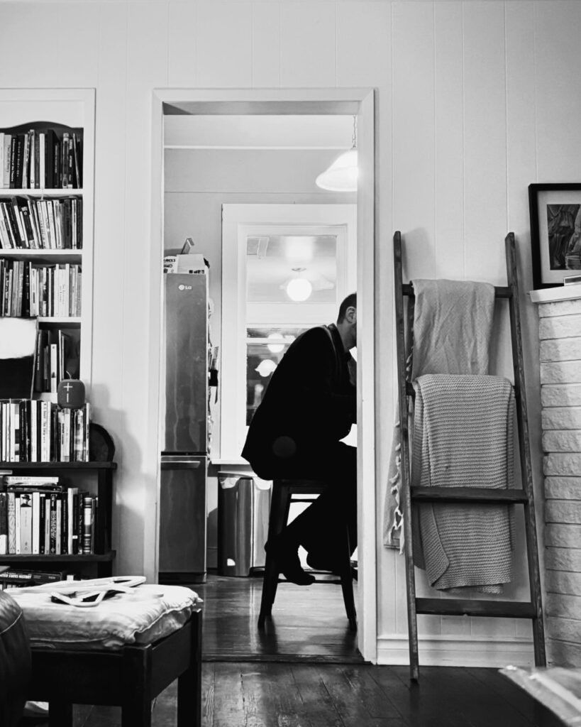 John sitting at his desk.